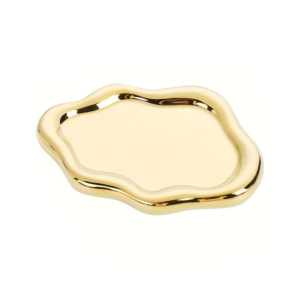 Polished gold cloud-shaped ceramic tray with a raised wavy rim, on an off-white background