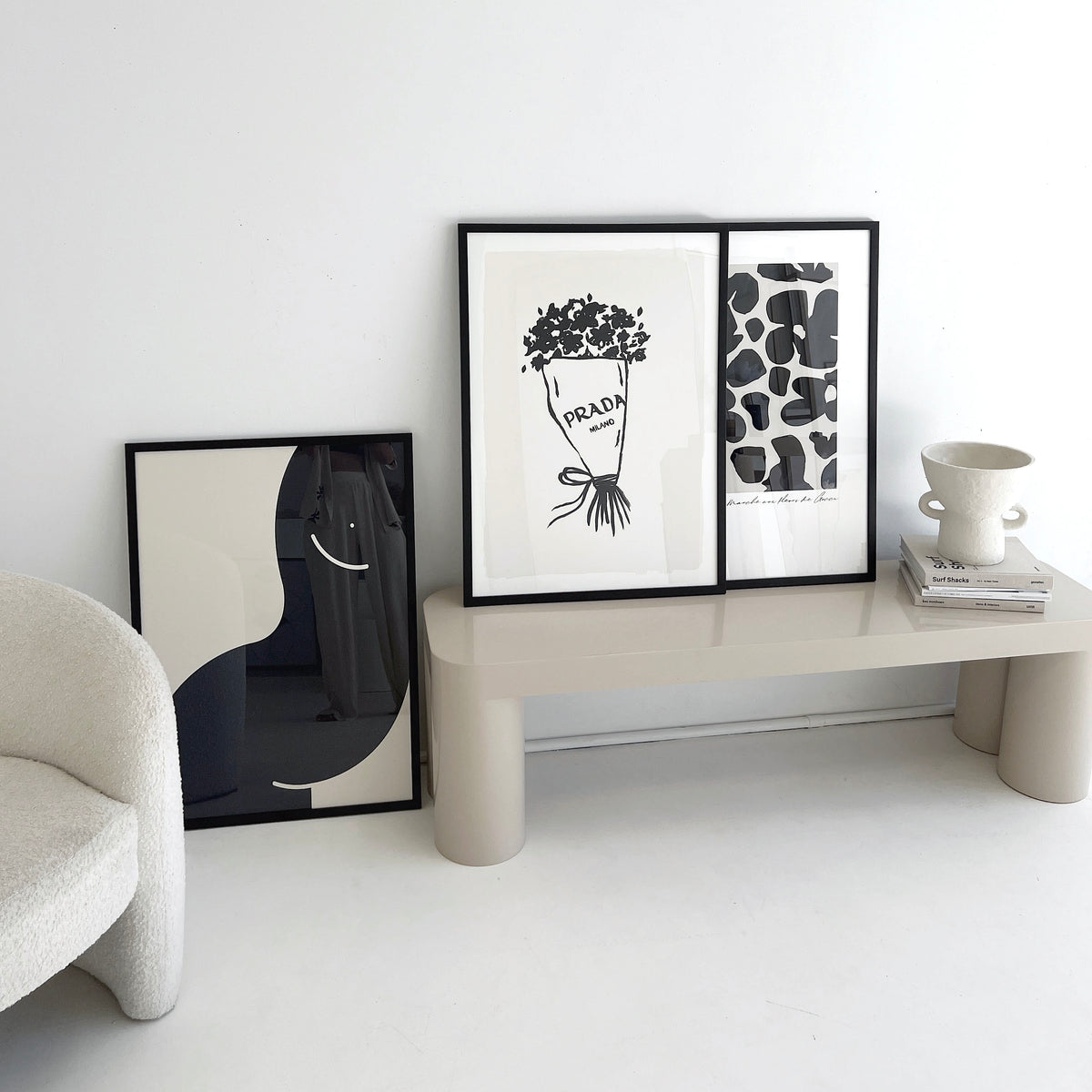 Gucci Flower Market print in navy framed on a cream bench beside two other prints and a vase