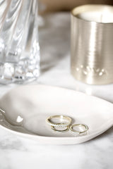 Haan ceramic condiment dish in soft neutral glaze styled on marble with gold rings and candle
