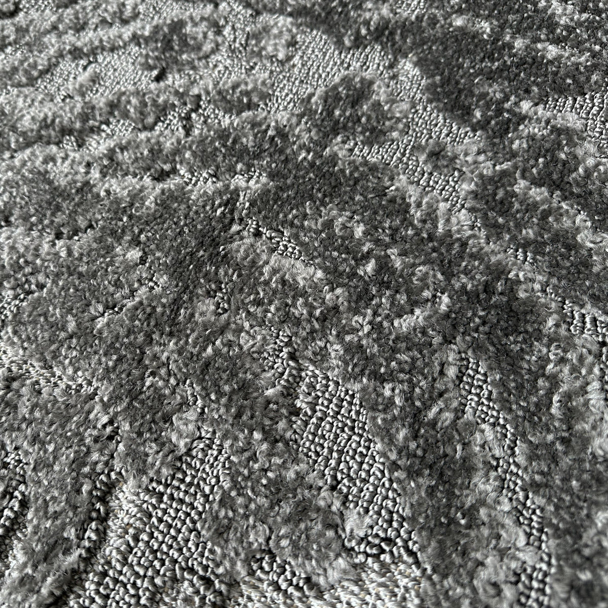 Close view of the dark grey high-low pile with its fluid pattern