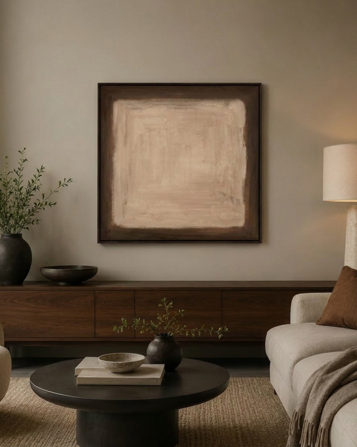 Hardly Anything Print above a walnut sideboard with black vases, a linen lamp and a round dark coffee table
