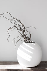 Harmie organic ceramic vase in white styled with sculptural branches on wooden console