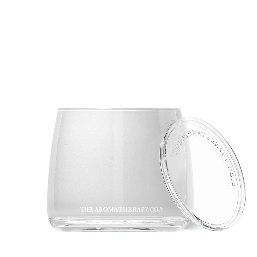 Therapy candle in a frosted white glass vessel with its lid off