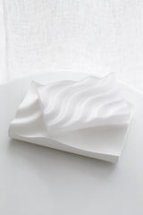Ripple 3D printed soap tray with sculptural wavy ridges in clear/eggshell tone, styled on a white surface in soft natural light