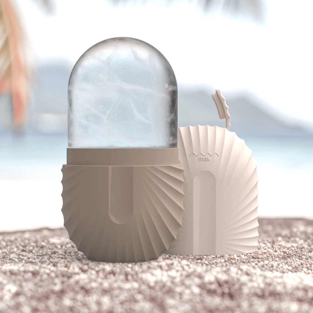 Beige ice roller and cover standing on sand with a blurred beach and palm backdrop