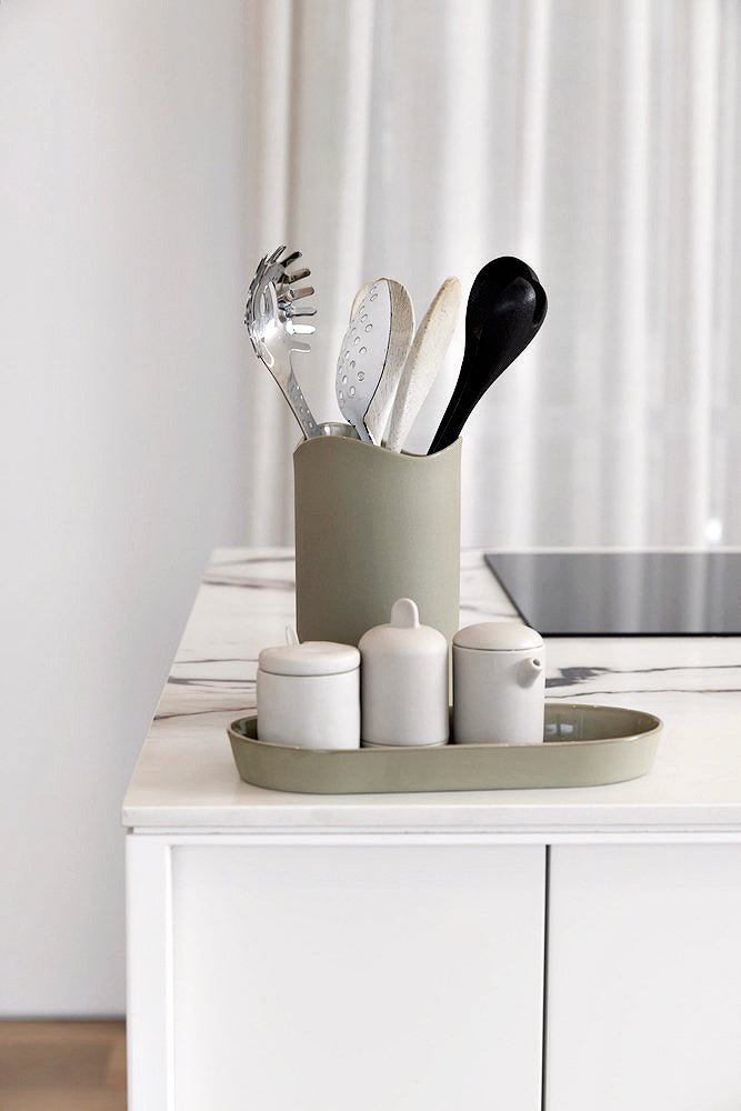 Sage green Jos utensil holder with cooking utensils, styled on a white marble look kitchen bench with a matching tray and white canisters
