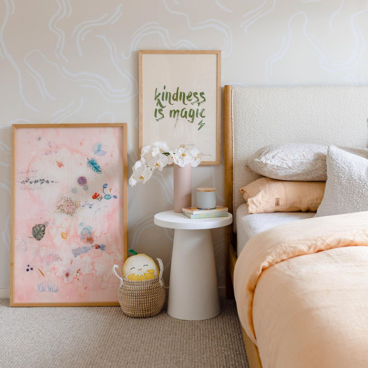 Kindness Is Magic print in khaki framed beside a pink abstract print in a child's bedroom