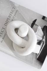 White sculptural knot styled as standalone accent piece