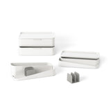 A Glam Cosmetic Organizer Large by Umbra, perfect for makeup and skincare, featuring a set of white and gray storage boxes neatly arranged on a white surface.