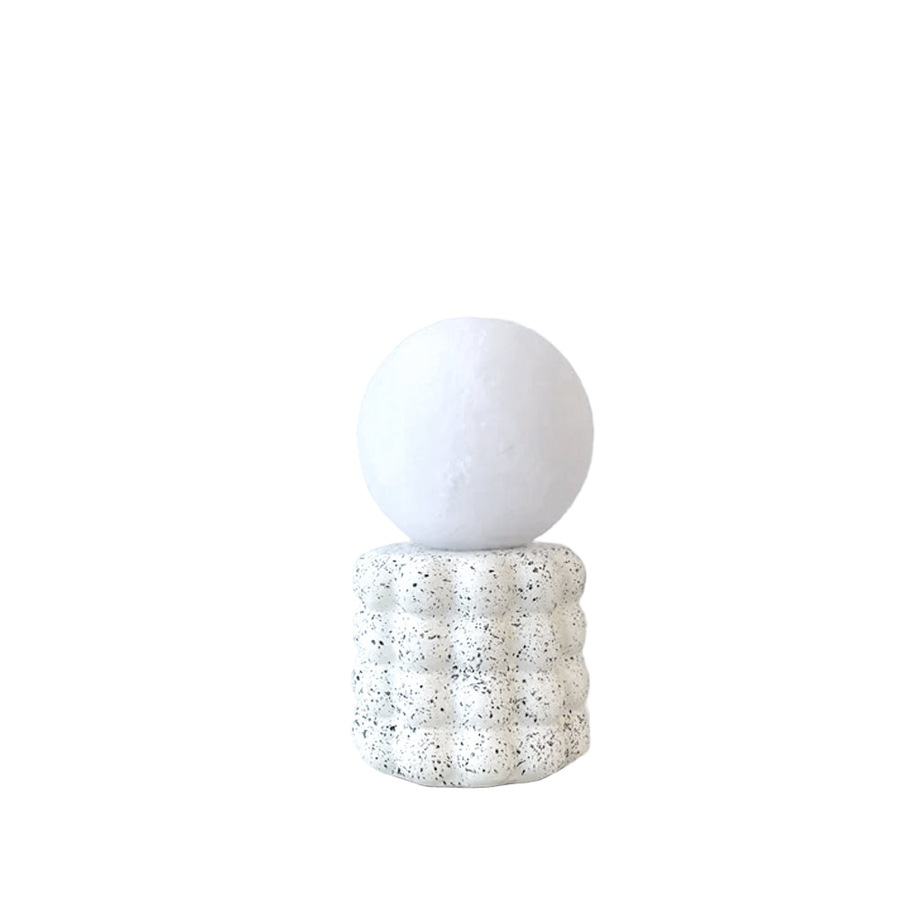 Elara Glow lamp with a white globe shade on a speckled cream base, plain background