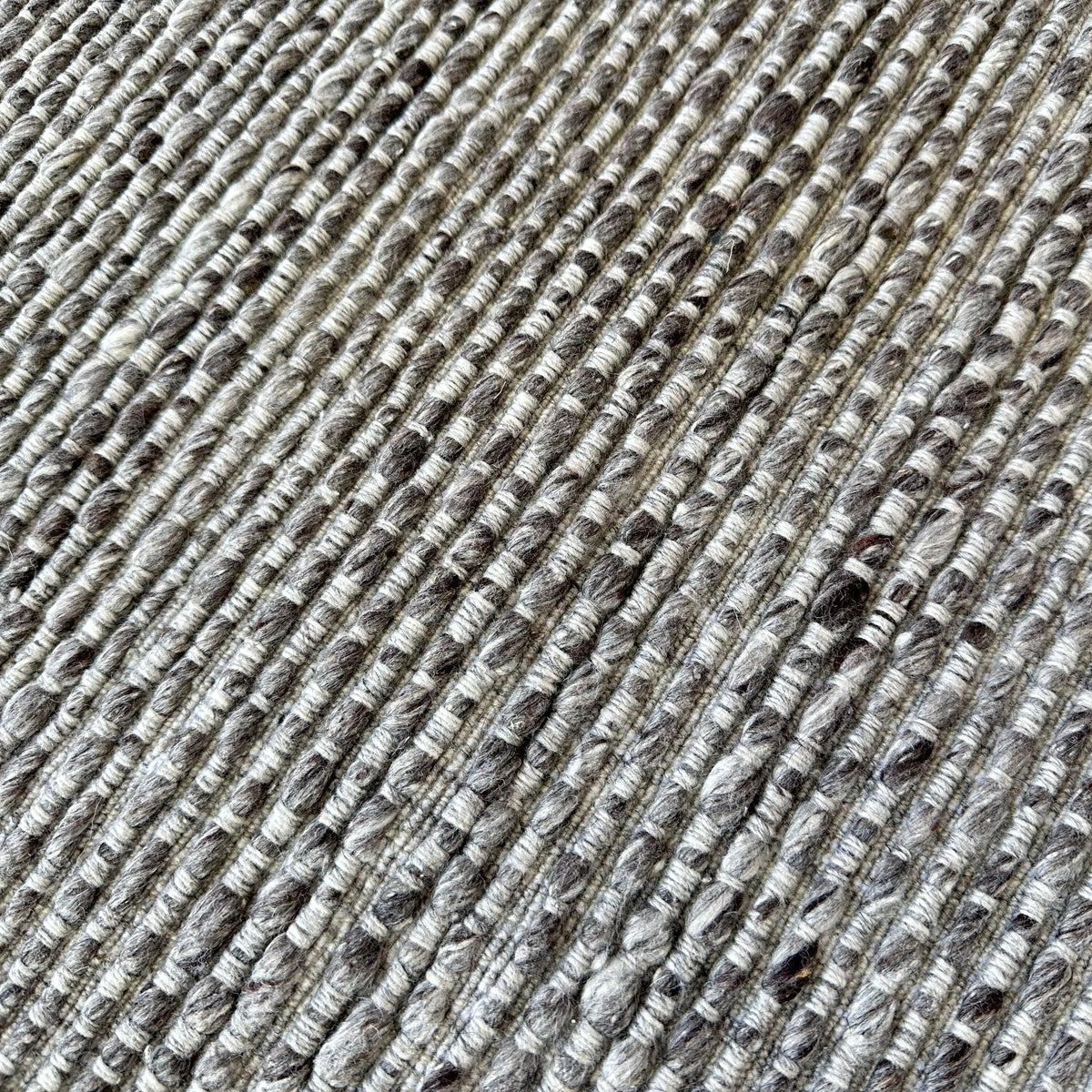 Close view of the raised grey rib and flecked wool blend yarn