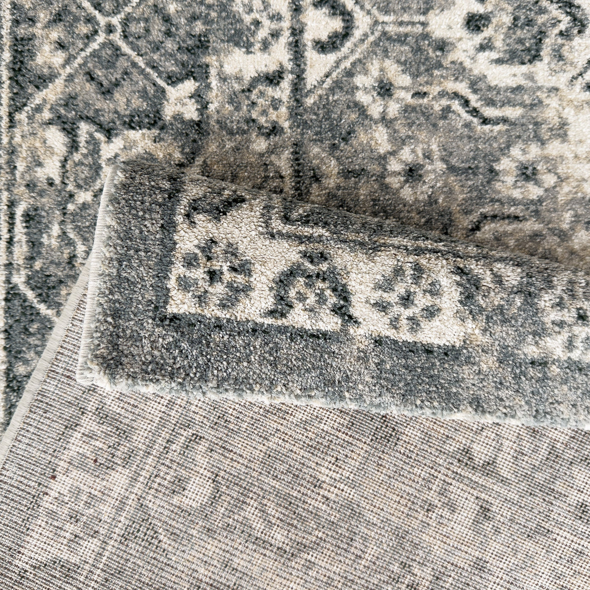 Folded corner showing the patterned pile and the pale woven backing