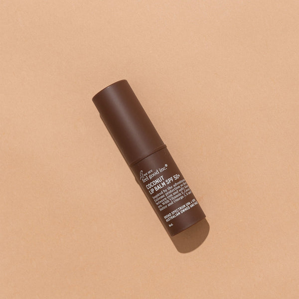 A tube of Coconut Lip Balm SPF 50+ from We Are Feel Good Inc. with extreme protection and SPF 50+ on a tan background.