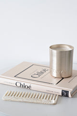 Little Book of Chloé fashion book styled with Ecoya candle and marble comb on neutral table.
