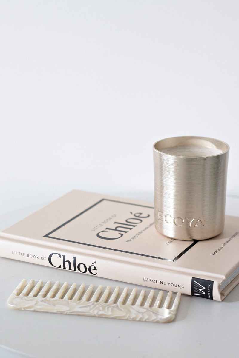 Little Book of Chloé fashion book styled with Ecoya candle and marble comb on neutral table.