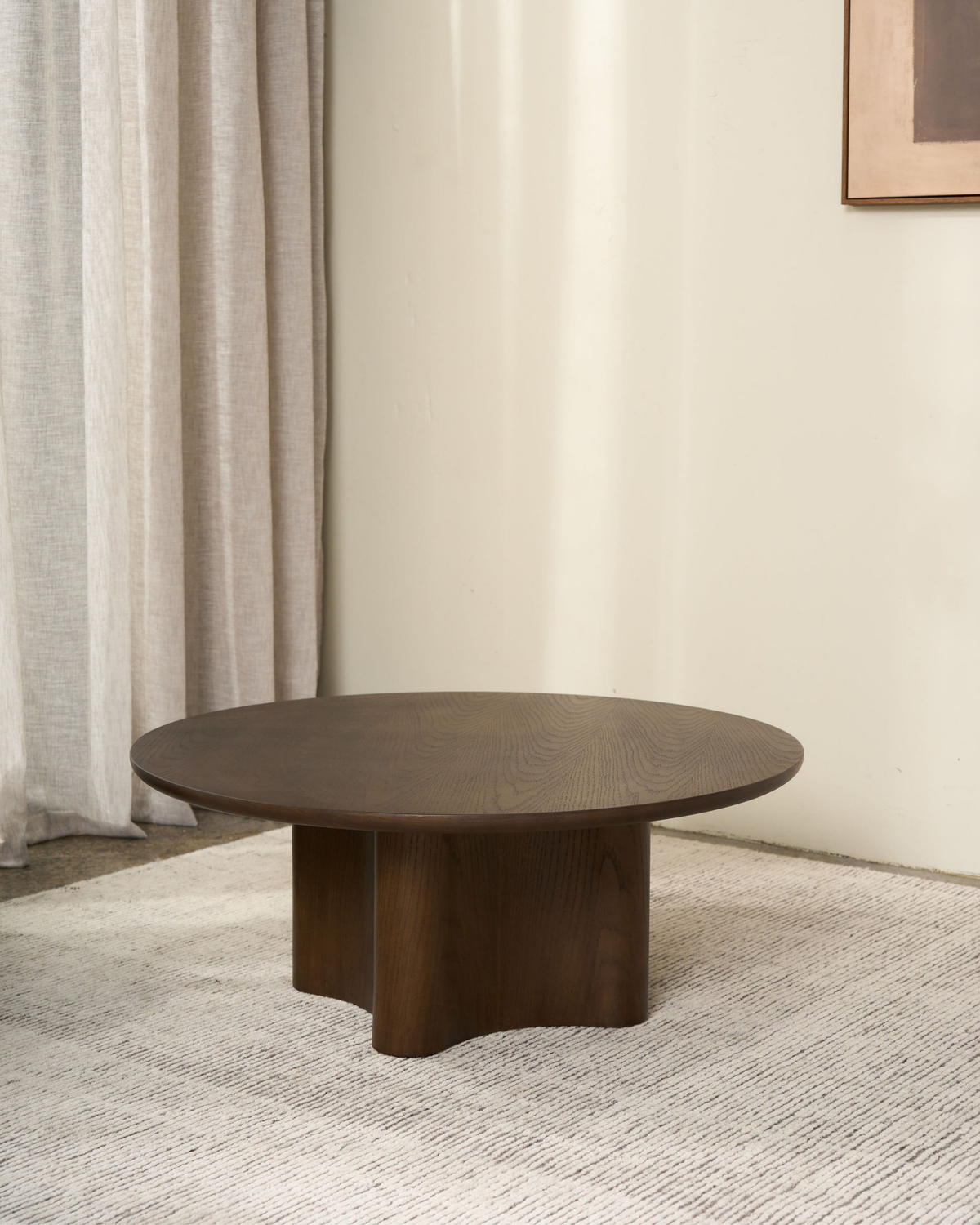 Brown Oak Luma Coffee Table on a textured cream rug beside sheer linen curtains