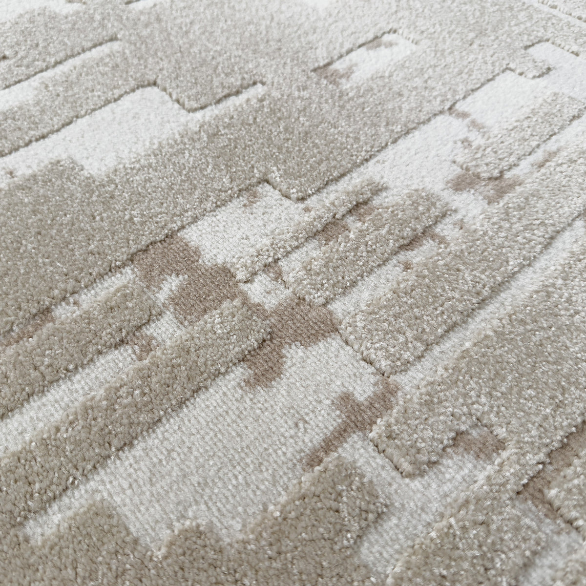 Close view of the high-low pile with raised beige and ivory shapes
