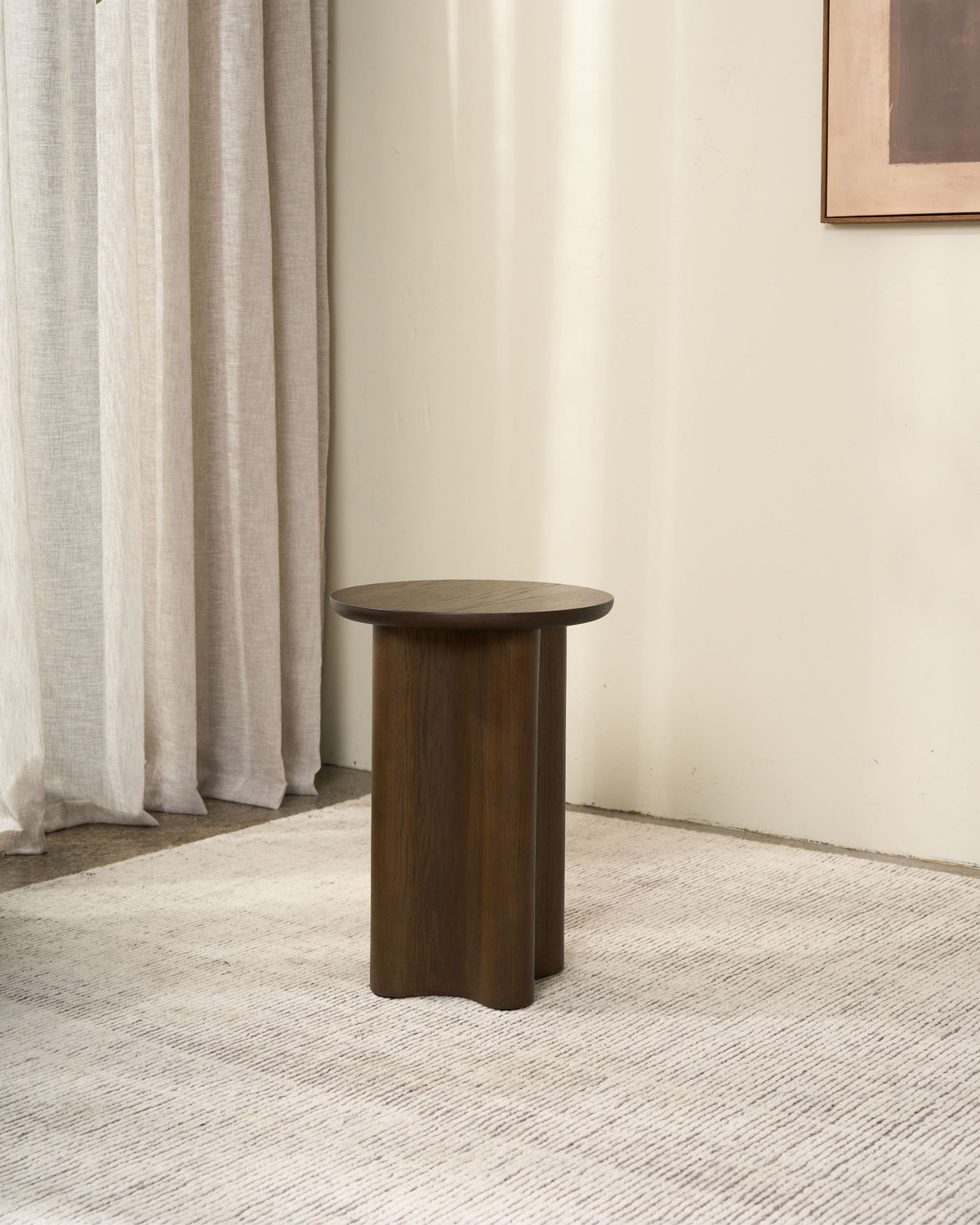 Brown Oak Luma Side Table on a textured cream rug beside sheer linen curtains