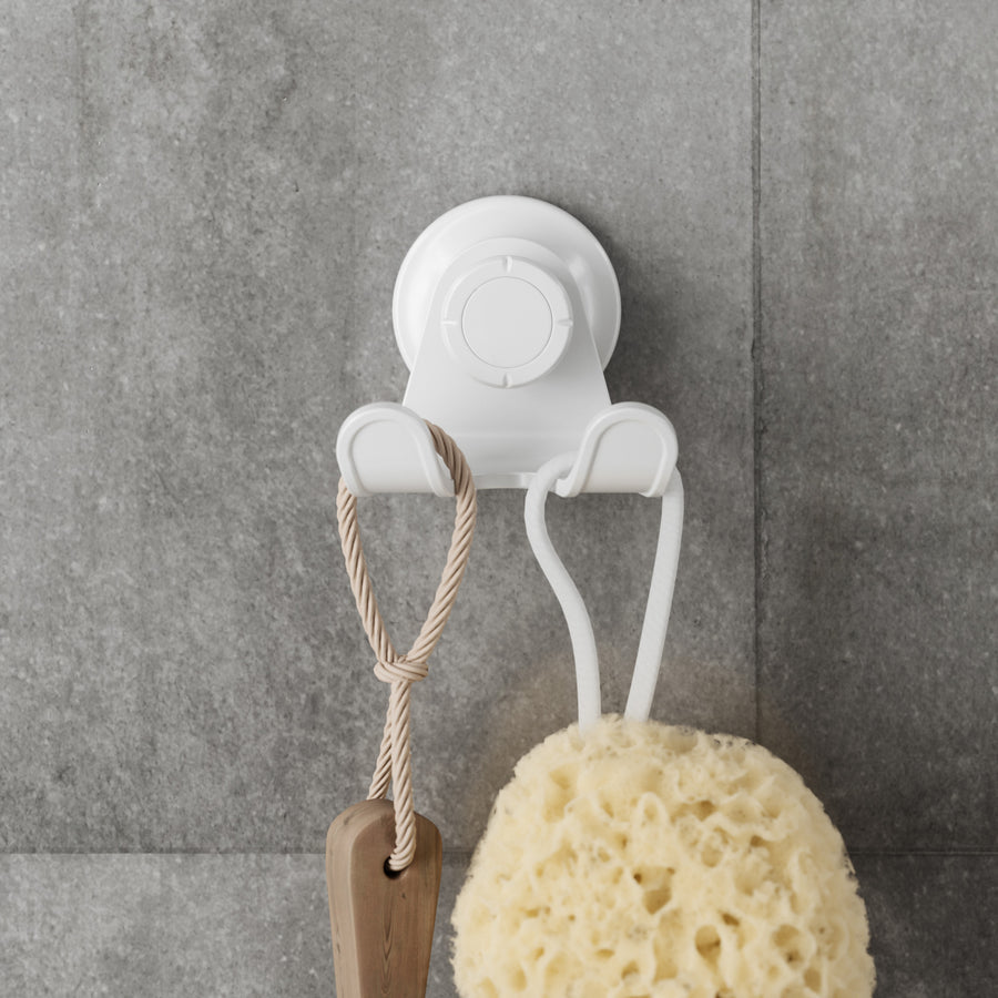 Umbra Flex adhesive double hook in white holding a sponge and brush on grey tiles