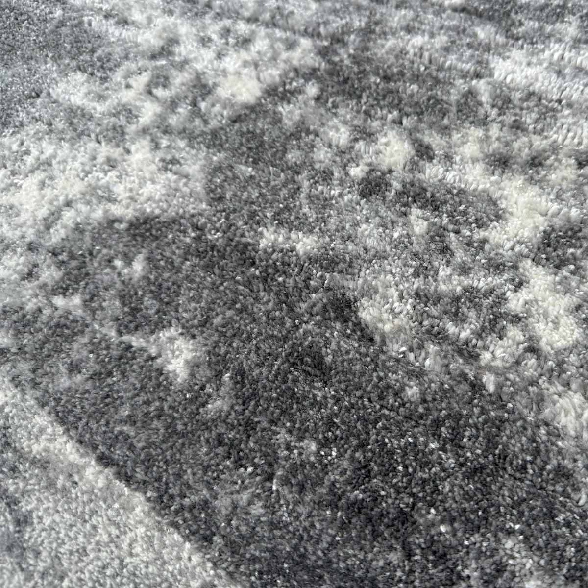 Close view of the softly textured grey pile with charcoal and white patches