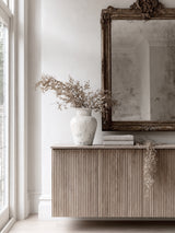 Mariella 40cm distressed stone terracotta vase with dried botanical branches styled on fluted oak sideboard beneath ornate antiqued mirror