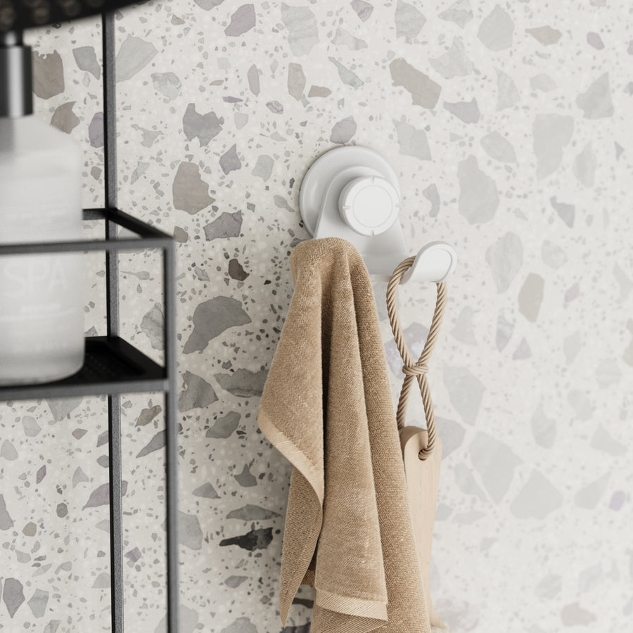 Umbra Flex adhesive double hook in white holding a towel on a terrazzo wall