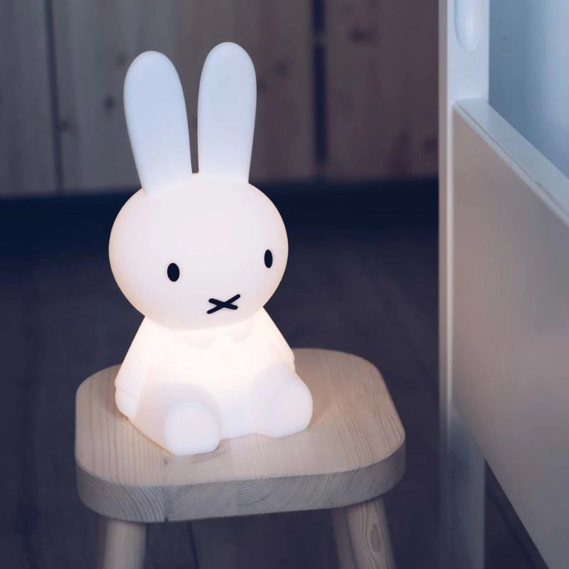 Miffy First Light by Mr Maria glowing on a small timber stool in a dim room