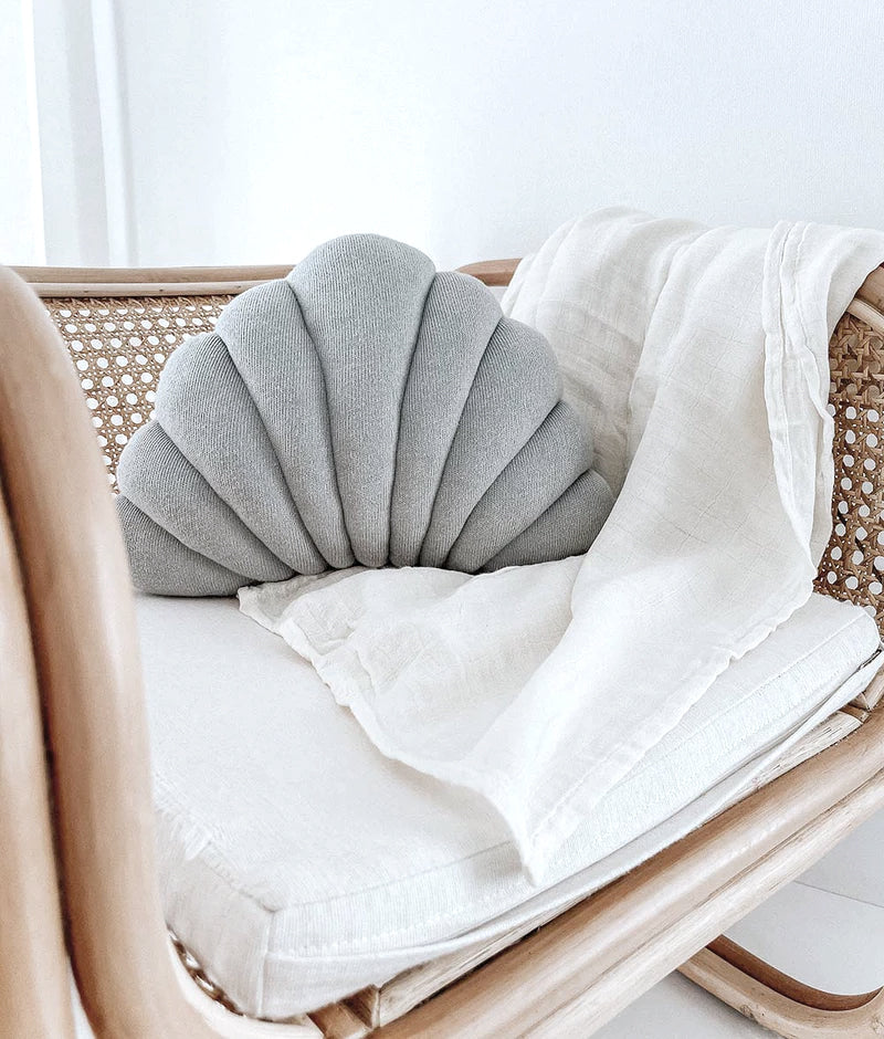 Small Shell Cushion in Mist on a rattan chair with a soft white linen throw