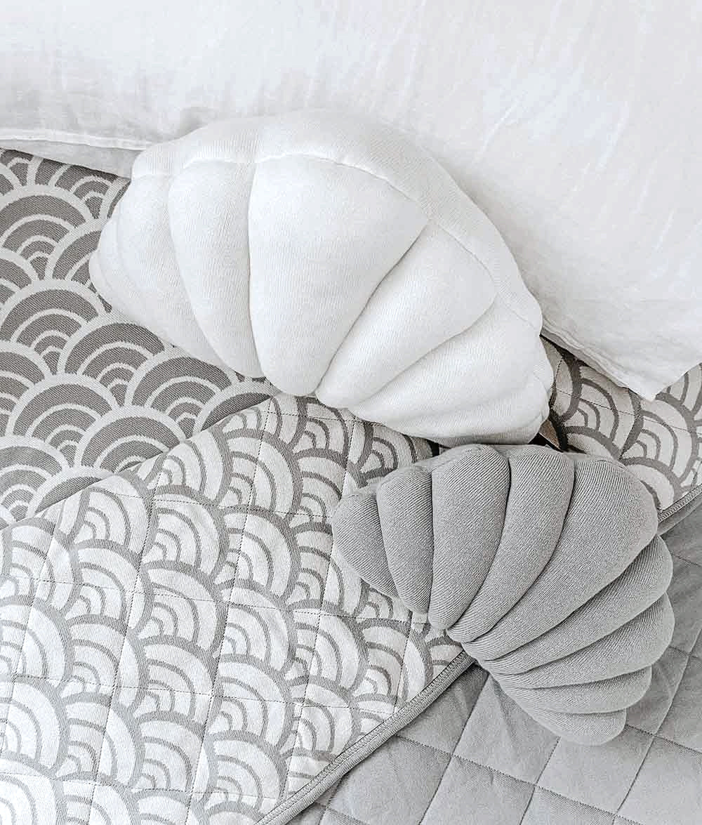 Small Shell Cushion in Mist with an ivory shell cushion on a grey wave print quilt