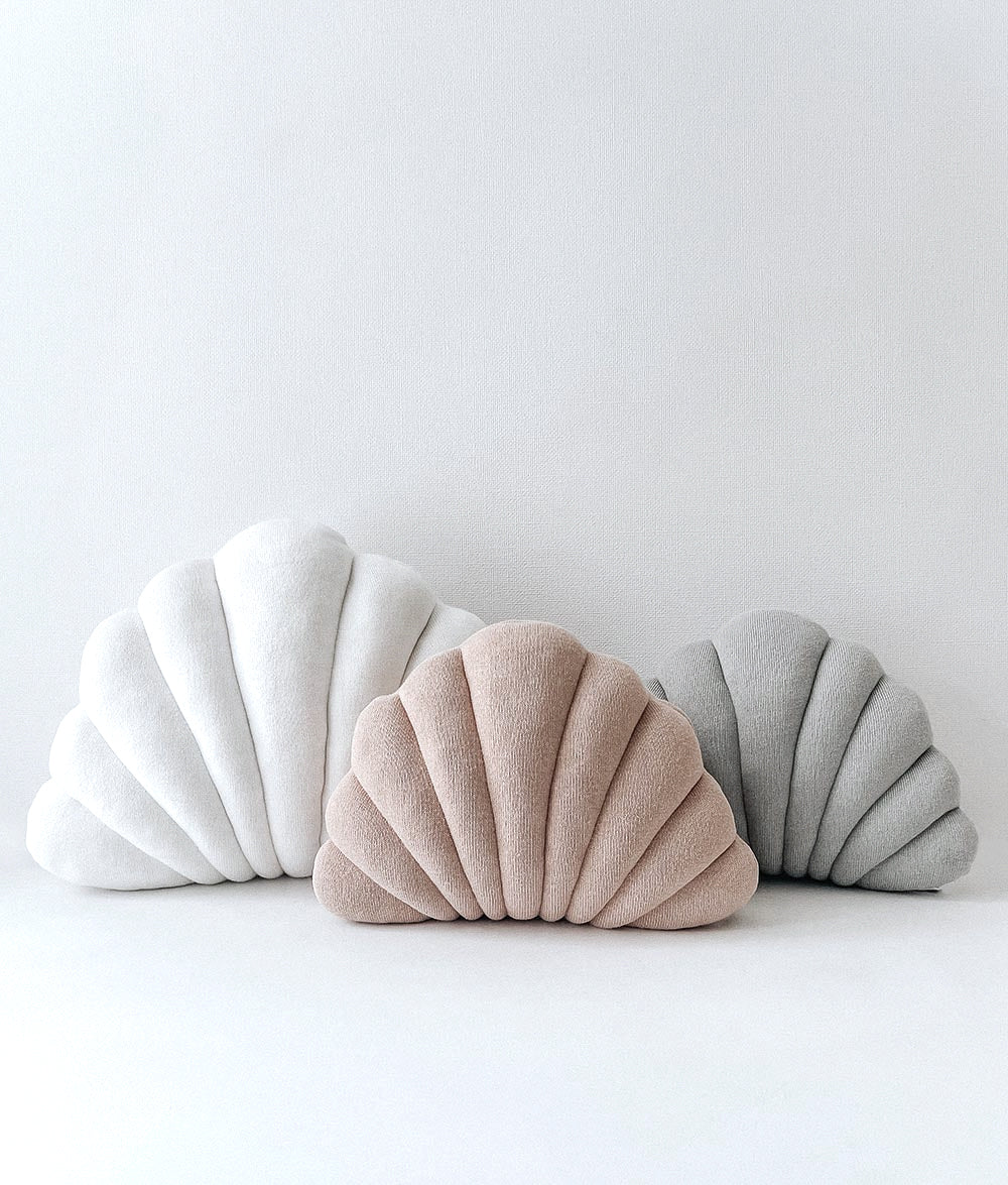 Small Shell Cushion in Mist beside ivory and taupe shell cushions on a white backdrop