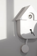 Karlsson Modern Cuckoo Clock in white with pendulum detail, styled on wall with minimalist shadows; Scandinavian home décor.