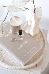 Decorative stone tray with vase and books on wooden surface