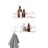Two Cubiko Shower Bins, Set of 2 with adhesive installation, bent wire design, towels, and soaps on them. (Umbra)