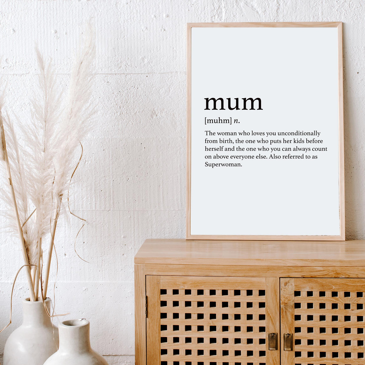 Mum print in a natural frame on a timber cabinet beside dried pampas