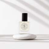 A bottle of ROUGE perfume by The Perfume Oil Company, inspired by Baccarat Rouge 540, filled with fragrance oils, sitting on top of a white stone.