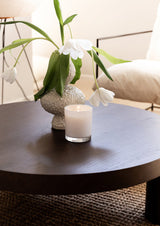 Naturals candle neroli amber wood styled on dark wood coffee table with flowers