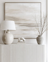 Nerina large sage stone vase holding bare winter branches on fluted white sideboard beside ceramic lamp and abstract neutral canvas