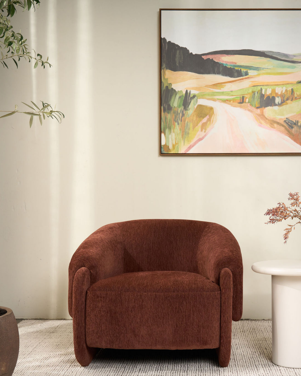 Front view of the Umber chair beneath a framed landscape painting