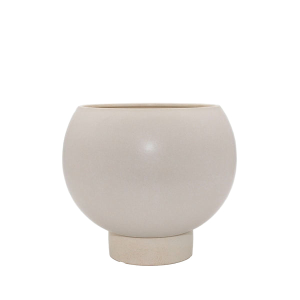 Neutral stoneware planter with curved silhouette and built-in plinth