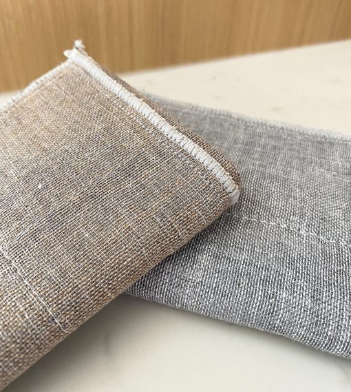 Close view of charcoal grey and natural face cloths showing their woven texture