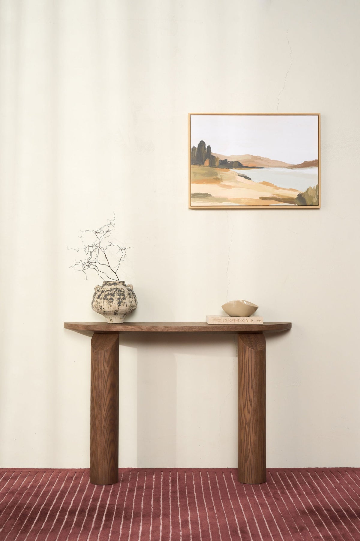 Brown Ash console styled with a textured vase of dry branches, a book and a small bowl