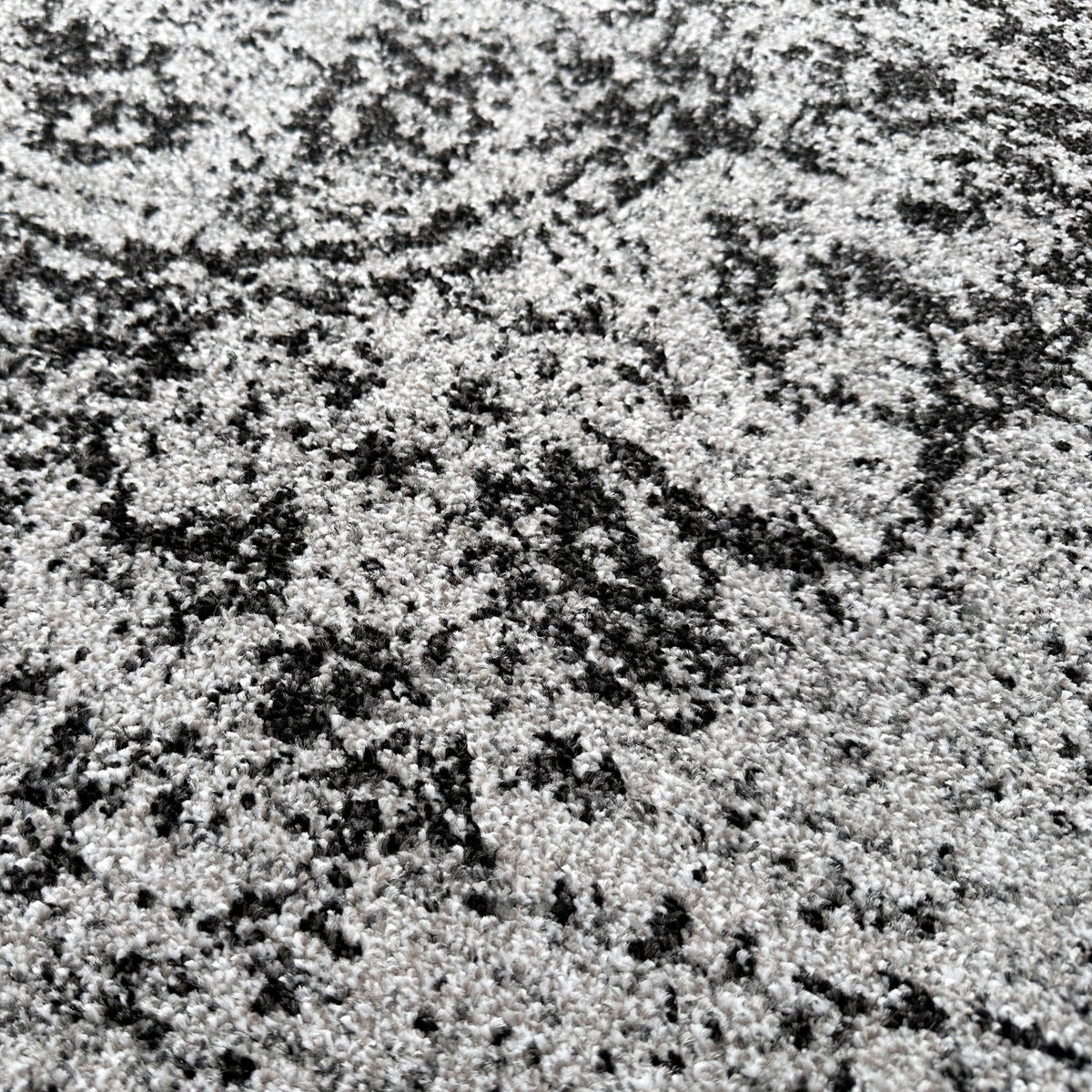 Close view of the grey and black pile showing the faded vintage pattern