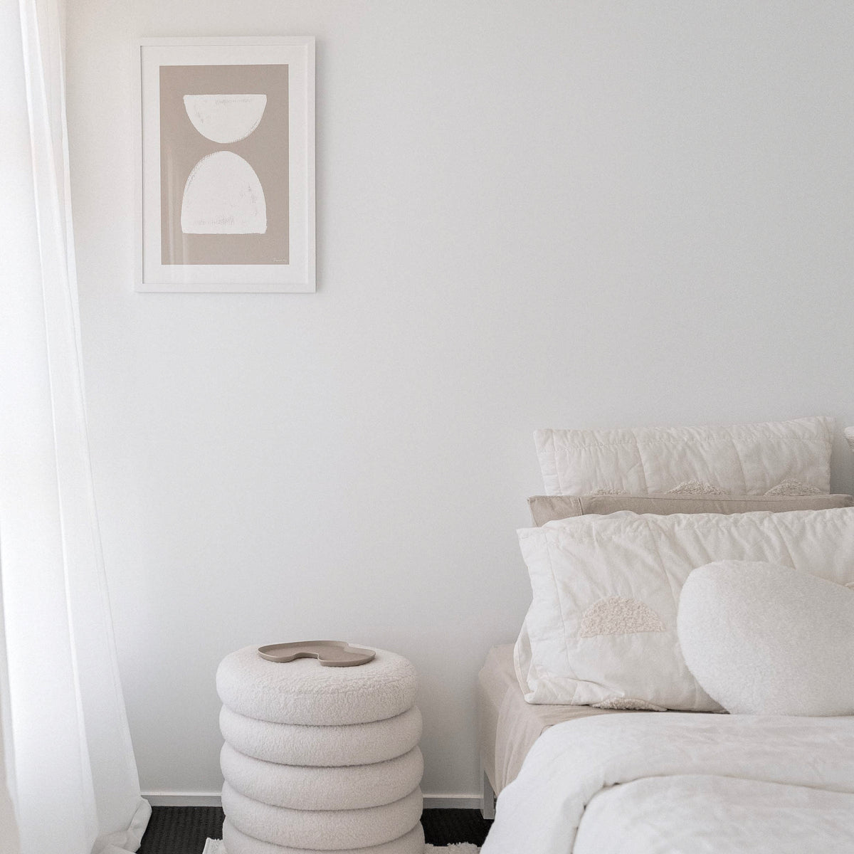 Painted Shapes print in natural, framed above a bedside stool in a soft white bedroom