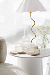 Papier HQ Amalfi fluted glass tumblers and decanter on timber tray beside wavy gold table lamp and rippled crystal vase