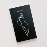 A stylish black HOMEBODII notebook with a line drawing of a woman, perfect as a gift for stationery lovers. Brand name: Papier HQ.