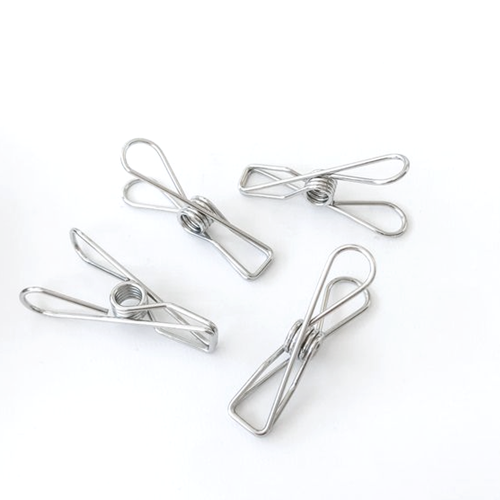 Four stainless steel clothes pegs on a white background