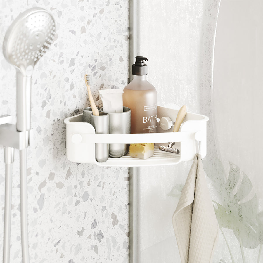 Umbra Flex corner bin in white holding a bath bottle, cup and toothbrushes