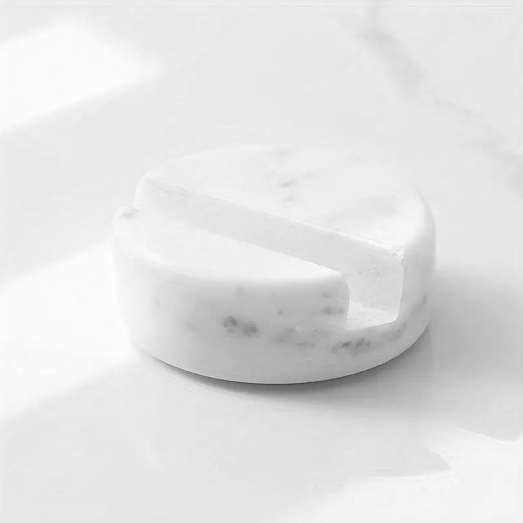White marble phone stand on a white marble surface