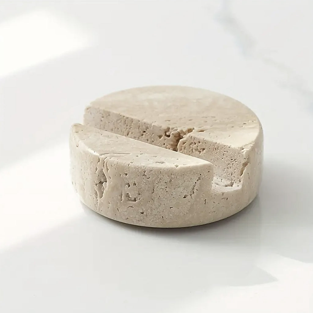 Travertine phone stand on a white marble surface