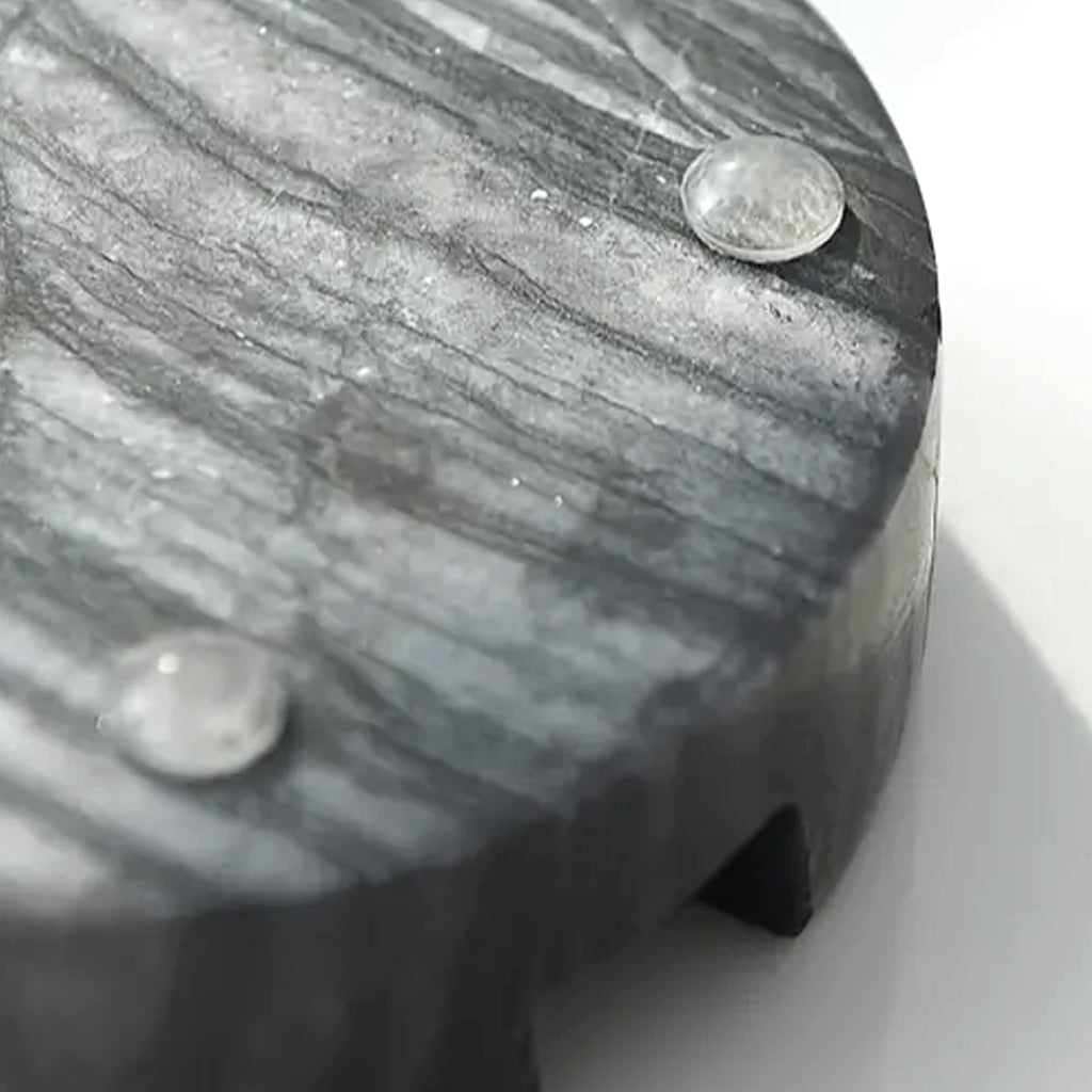Underside of the black marble phone stand showing its clear protective feet